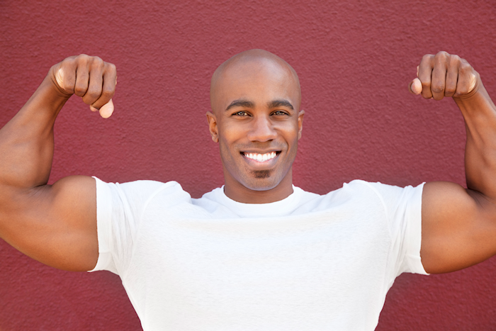 Man flexing large biceps while smiling