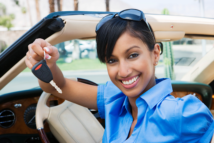 Woman holding a key happy with her car brand