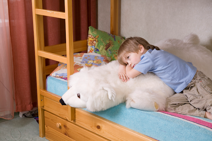 unhappy child on his bunk bed